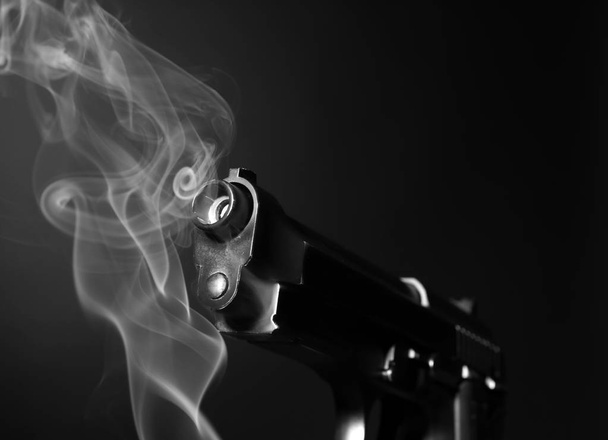 Pistolet fumeur sur fond sombre
 - Photo, image