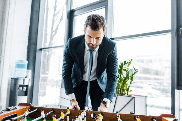  bearded businessman in formal wear playing table football  - Photo, Image