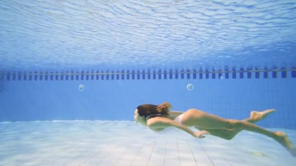 Búvárkodás a medencében, egy napsütéses napon fehér bikini szexi nő - Felvétel, videó