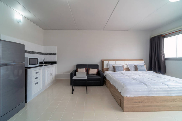 Camera da letto di lusso con divano in pelle di soggiorno e cucina nella stessa zona, Studio tipo di condominio o appartamento, appartamento di servizio e alloggi Concept
 - Foto, immagini