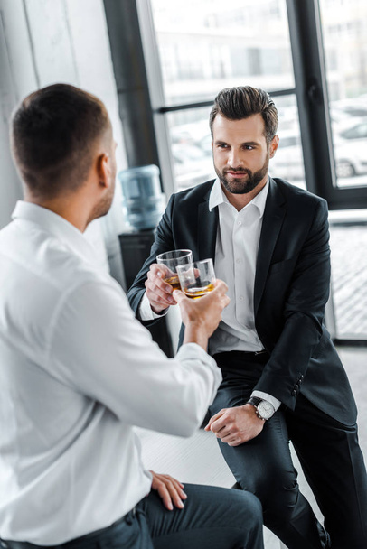 bearded businessman toasting with glass of whiskey with colleague  - Photo, image