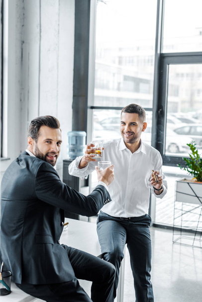 smiling businessmen toasting with glasses of whiskey  - Fotografie, Obrázek