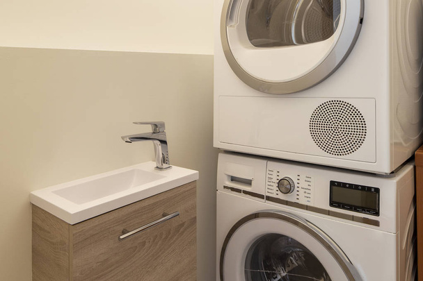 Laundry with washing machine, dryer and sink. Nobody inside - Zdjęcie, obraz