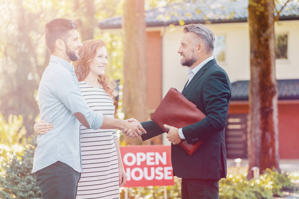 Real estate agent congratulating smiling couple buying home - 写真・画像