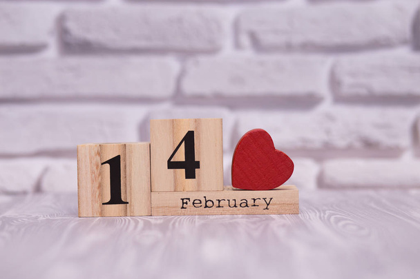 14 febbraio impostato su calendario in legno con cuore rosso su sfondo mattone bianco
. - Foto, immagini