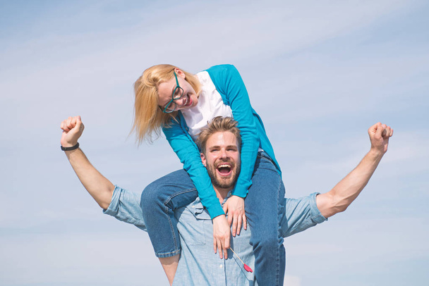 Couple happy date having fun together. Lovers enjoy date and feeling free. Freedom concept. Couple in love enjoy feeling freedom outdoor sunny day. Man carries girlfriend on shoulders, sky background - Foto, immagini
