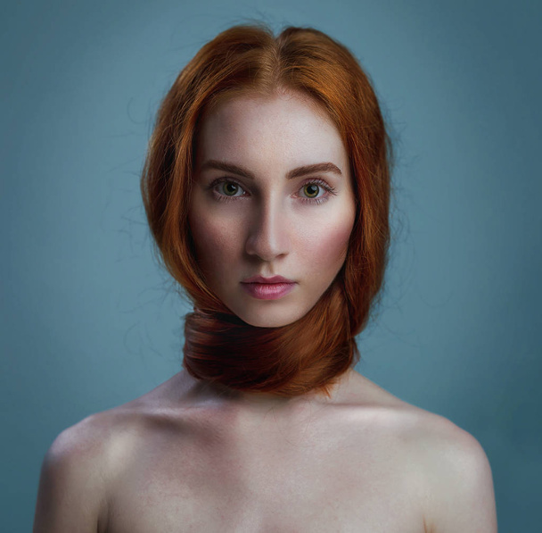 Εσωτερικη πορτρέτο του ένα πανέμορφο κόκκινο επικεφαλής γυναίκα με γυμνά ώμους εκκαθάριση με μακριά ίσια μαλλιά τυλιγμένα γύρω από το λαιμό. Απομονωμένα σε ανοιχτό γαλάζιο φόντο. Αντίγραφο-space - Φωτογραφία, εικόνα