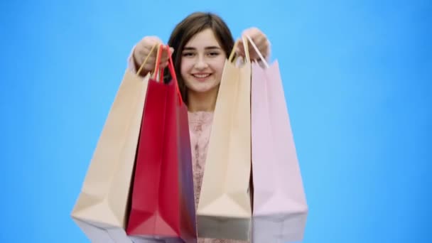 Mladá hezká holka dělá neuvěřitelně příjemné nakupování. Během této doby ona dává nákupní tašky na ruce. - Záběry, video