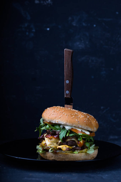 黒皿にナイフで古典的なハンバーガー - 写真・画像