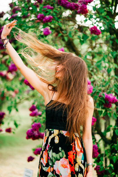 Young beautiful woman with long hair in summer blooming garden - Foto, Imagem