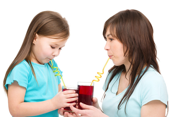 Mother and her daughter are drinking juice - Foto, imagen