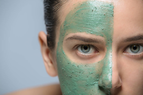 Jonge vrouw met groene gezichtsmasker - studio portret - Foto, afbeelding