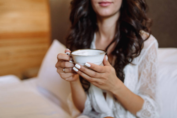 bride holds a cup of hot drink - Foto, imagen