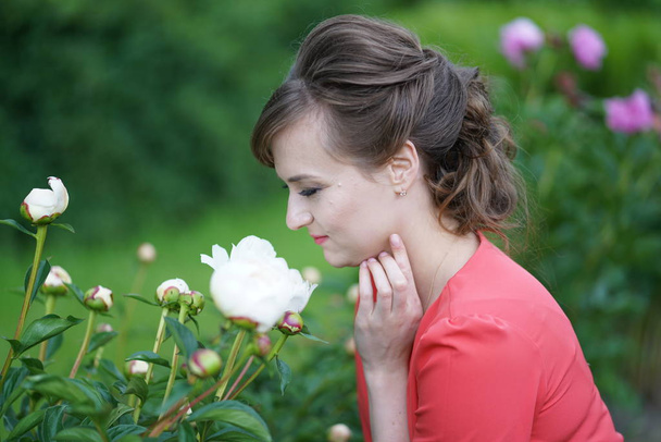 sonriente mujer adulta caucásica feliz relajarse en su jardín con flores en flor
 - Foto, Imagen