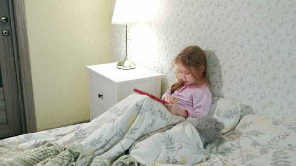 kis lány az ágyban, játszik a tabletta - Felvétel, videó