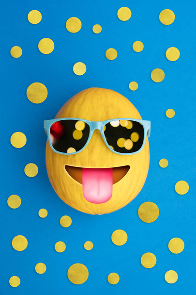 Divertido melón alegre con gafas de sol sobre un fondo azul colorido
  - Foto, imagen