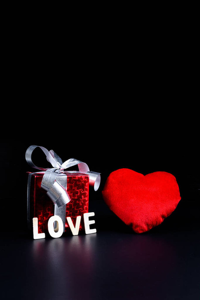 Valentine's day Concept Gift box, heart shape and Wooden letters word "LOVE" on black background and empty space for your graphic. Reminder for couples to express love - Zdjęcie, obraz