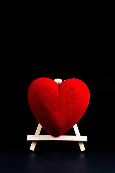 Valentine's day Concept heart shape on Wooden stand on black background and empty space for your graphic. Reminder for couples to express love - Photo, image