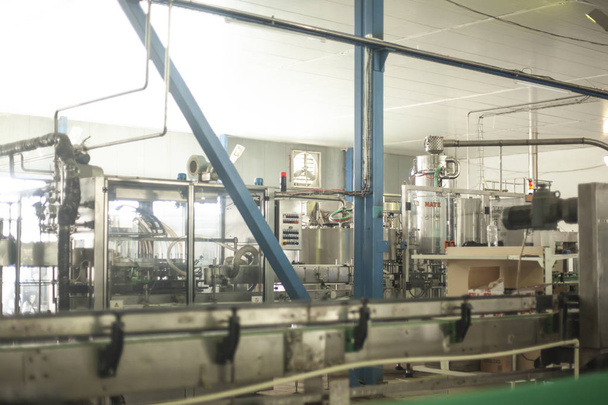 Botellas de vidrio en la línea de transporte automático en la fábrica de champán, cerveza o vino. Planta para embotellar bebidas alcohólicas
 - Foto, imagen
