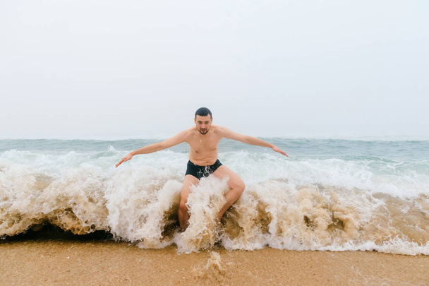 man standing in cold stormy sea - Photo, Image