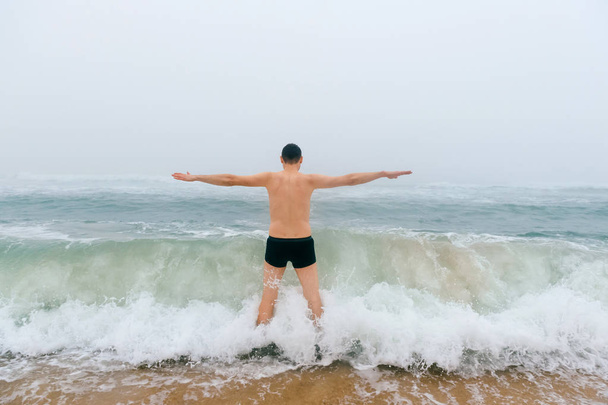 uomo in piedi nel freddo mare tempestoso
 - Foto, immagini