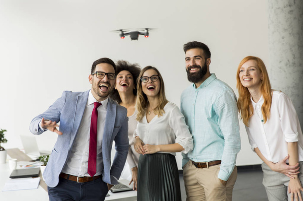 Jóvenes empresarios dejan que la cámara del dron vuele sobre la oficina y se divierta
 - Foto, imagen
