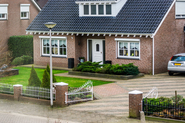 Luxuriöser holländischer Bungalow von der Straße aus, mit schönem Garten und einem Tor, moderne holländische Architektur, Haus in einem kleinen Dorf der Niederlande - Foto, Bild