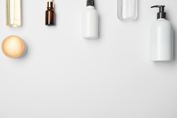 Vue du dessus de différentes bouteilles cosmétiques sur fond blanc avec espace de copie
 - Photo, image