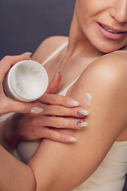 young beautiful woman with healthy skin applying cosmetic cream - Fotoğraf, Görsel