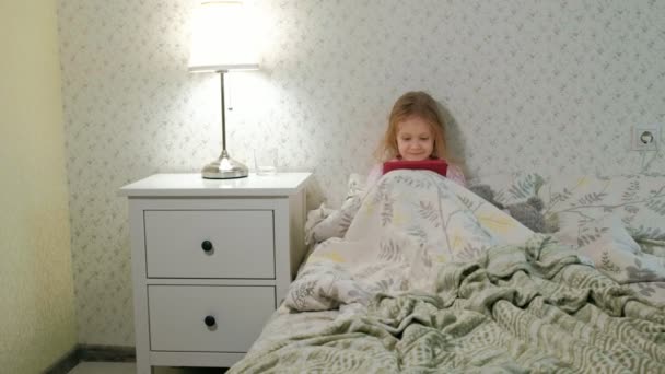 klein meisje in bed spelen op Tablet PC - Video