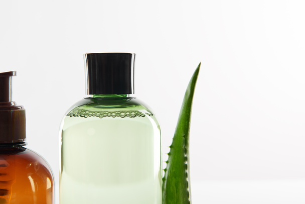 Dispensador cosmético con loción y frasco de suero en superficie blanca
 - Foto, imagen