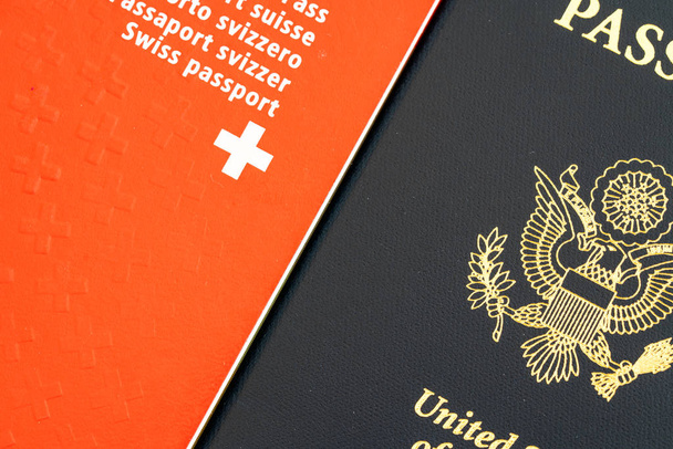 крупным планом вид на красный швейцарский паспорт и синий американский паспорт
 - Фото, изображение