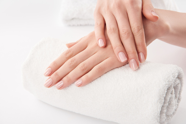 Partial view of female hands on terry towel on white background - Fotografie, Obrázek