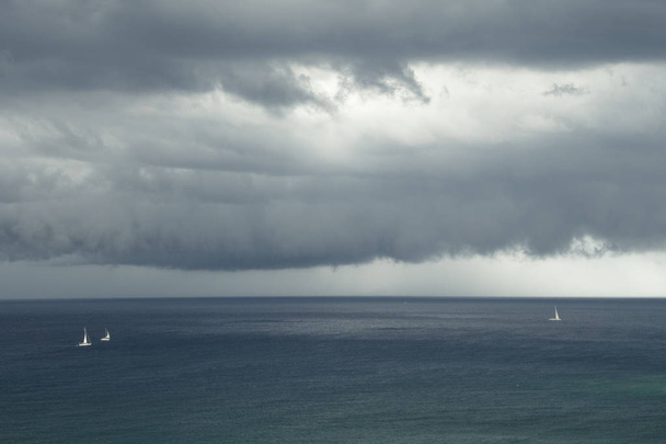 Stormy day at mediterranean ocean with grey clouds - 写真・画像