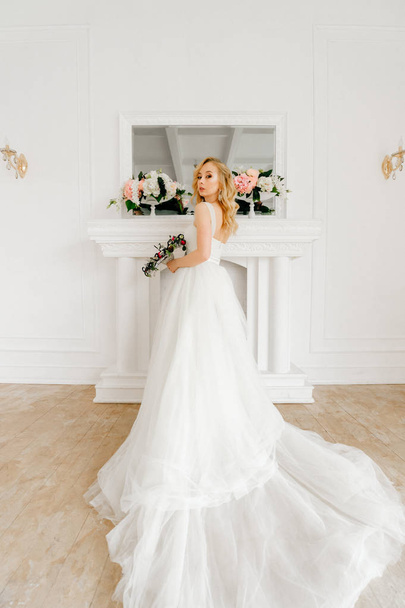 beautiful elegant bride in white stylish wedding dress posing in light room - Photo, Image