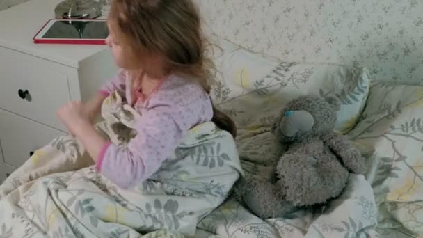 kis lány az ágyban, játszik a tabletta - Felvétel, videó