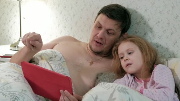 apa, és a kislányom az ágyon, játszik a tabletta - Felvétel, videó