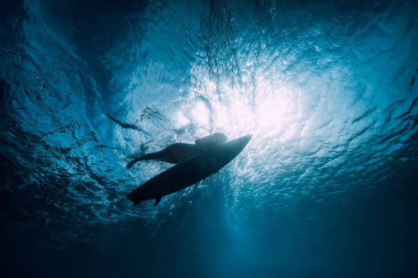 Surfeuse avec planche de surf plongée sous-marine avec vague sous-marine
. - Photo, image
