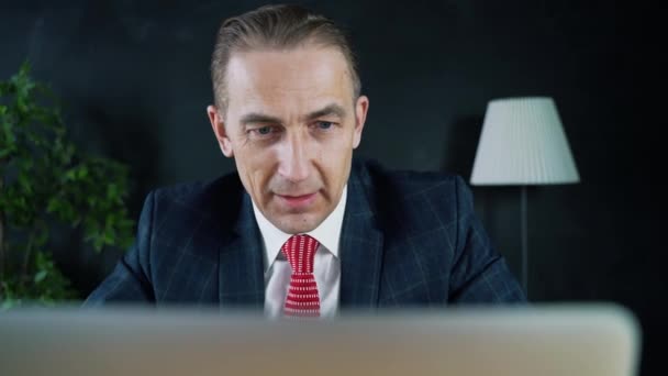 Man businessman or lawyer sitting at work in front of a laptop. - Video