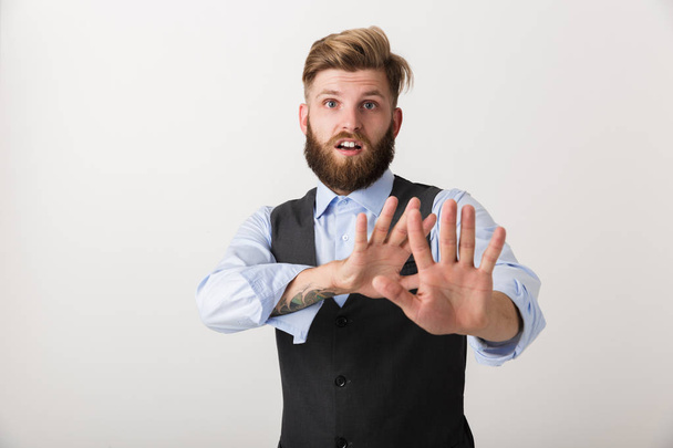 Image of a nervous young bearded man standing isolated over white wall background make stop gesture. - Φωτογραφία, εικόνα