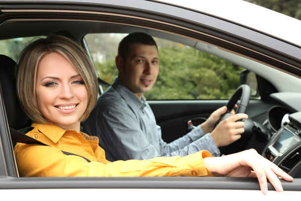 Portrait of young beautiful couple sitting in the car - Photo, Image