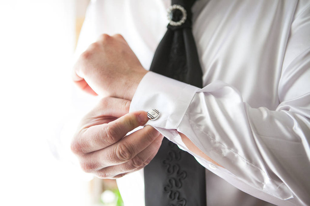 A man puts on an expensive shirt with cufflinks in the morning. - Valokuva, kuva
