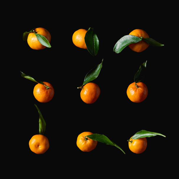 黒に分離された緑の葉でおいしいオレンジみかん - 写真・画像