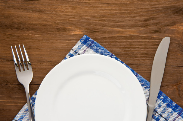 white plate, knife and fork on wood - Φωτογραφία, εικόνα
