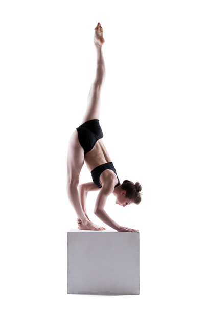 Beautiful girl posing doing exercises on cube - 写真・画像