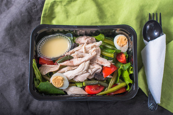 Fresh vegetable salad with chicken and eggs in plastic container - Фото, зображення