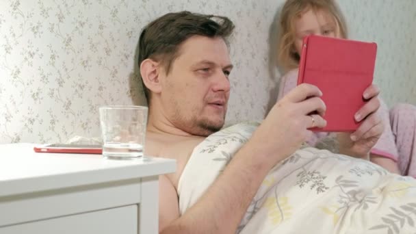 papa et petite fille sur le lit jouant sur la tablette
 - Séquence, vidéo