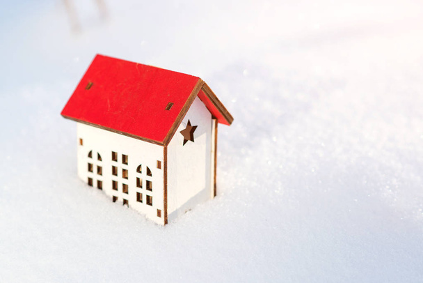 Modelo de casa en el fondo de nieve. El invierno. Casa protectora y aislante. Preparando la casa para el invierno. Concepto inmobiliario y inmobiliario
 - Foto, Imagen