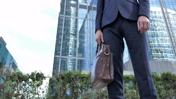 Επιχειρηματίας με τσάντα που στέκεται εκτός γραφείου - Φωτογραφία, εικόνα
