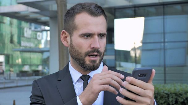 Geschockter, erstaunter Geschäftsmann nutzt Smartphone - Foto, Bild